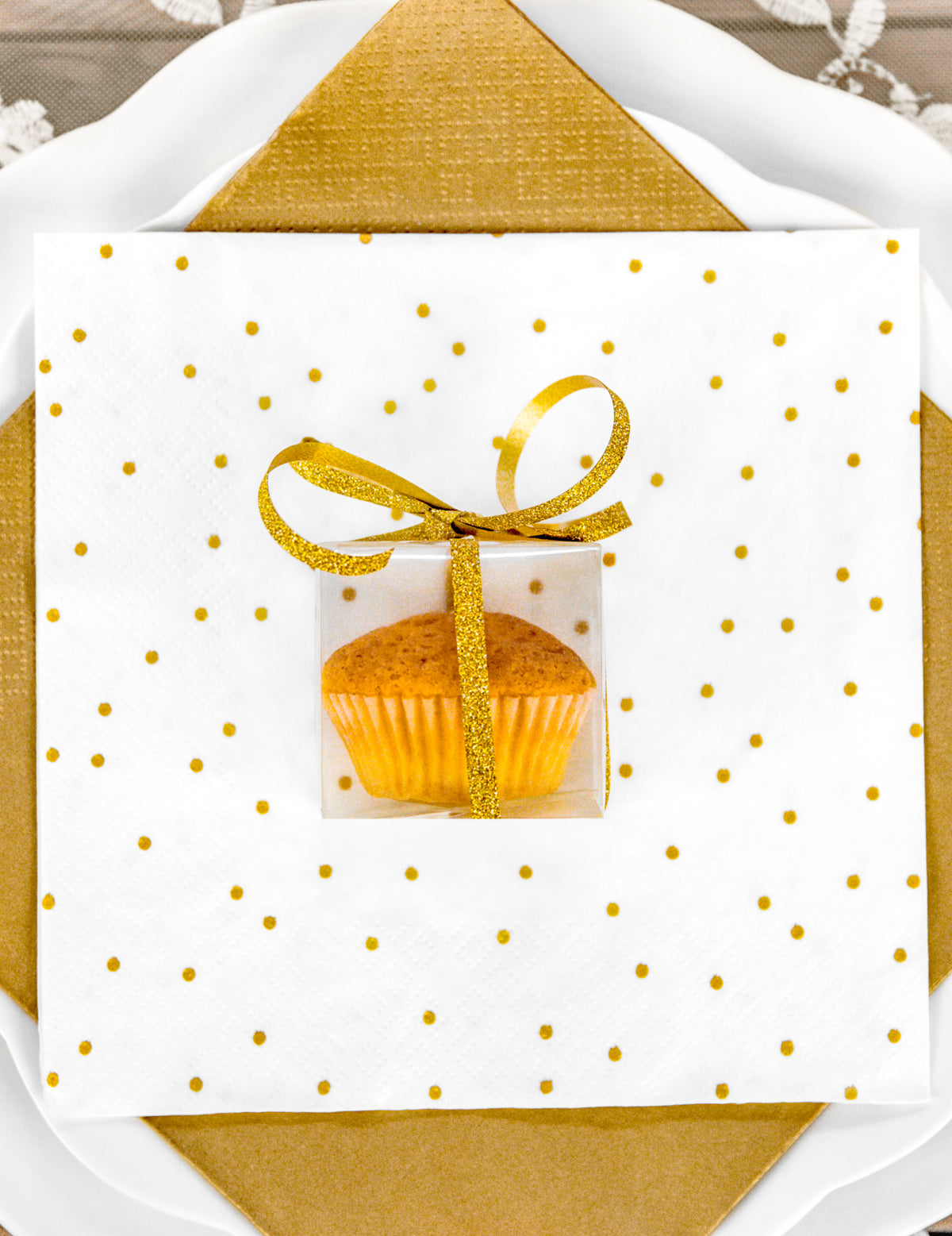 Postavitev s cupcakeom z majhnimi prozornimi darilnimi škatlicami za goste
