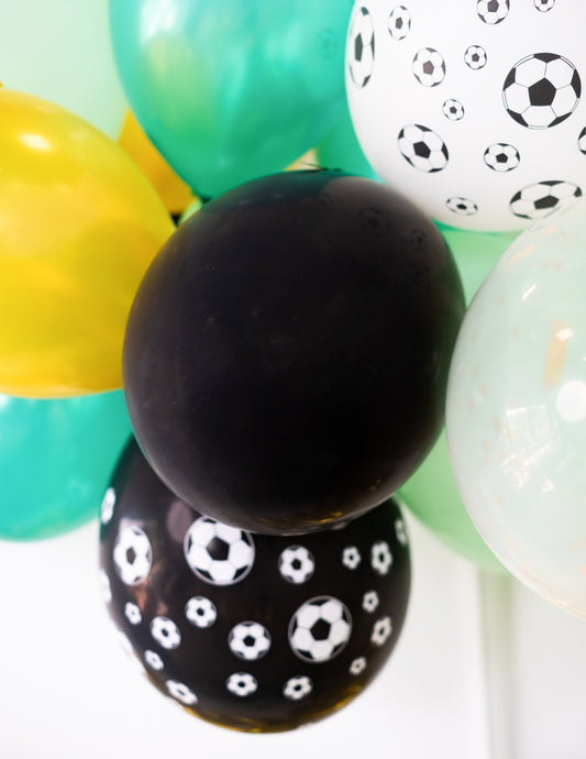 Gros plan sur les motifs ballons de foot des ballons noirs pour fête