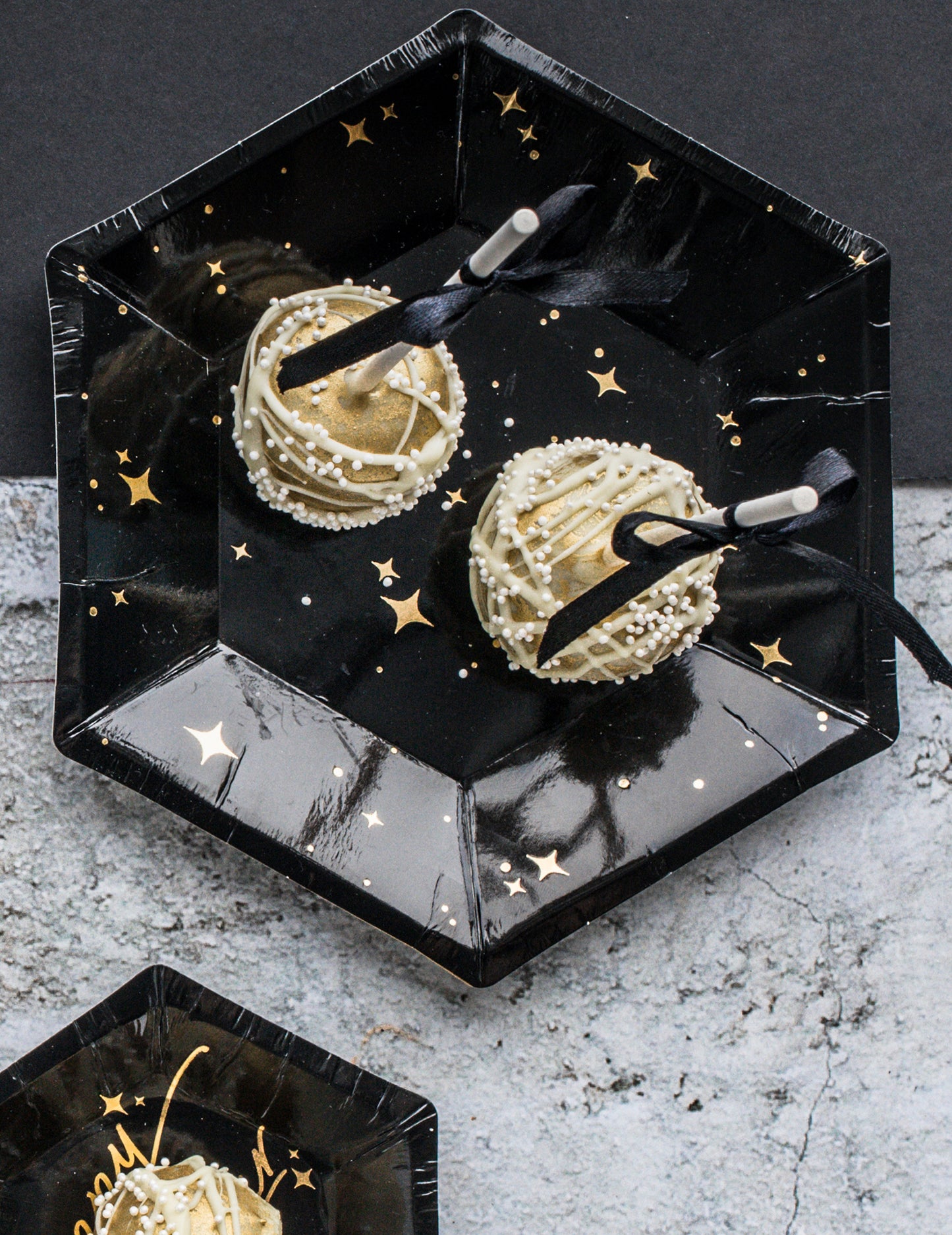 Gros plan sur les assiettes en carton hexagonales étoiles pour fête noires et dorées