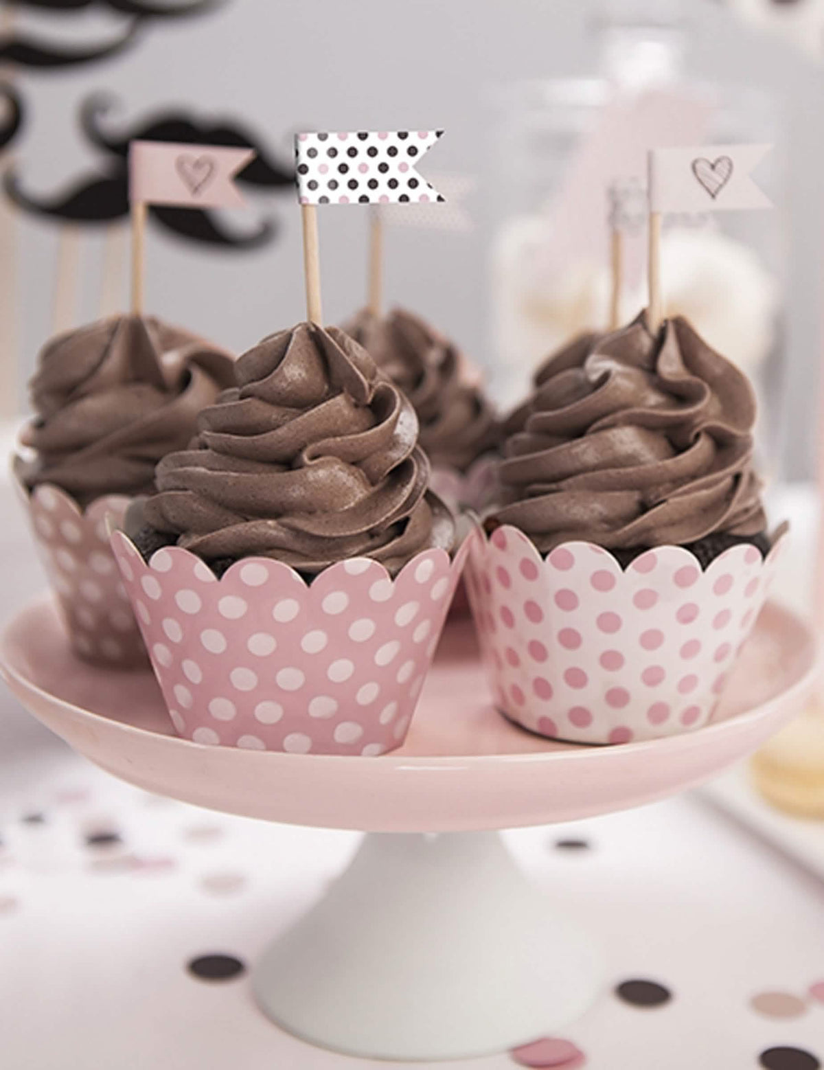 Postavitev ovojčkov za cupcake z roza pikami v pudrastem odtenku iz kartona