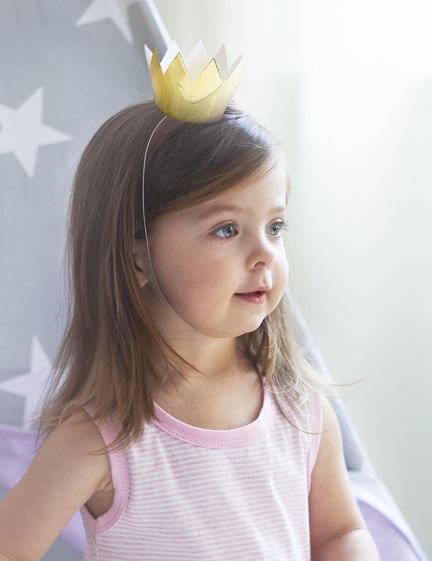 Vue portée par un enfant des 6 mini couronnes dorées pour fête en carton brillant