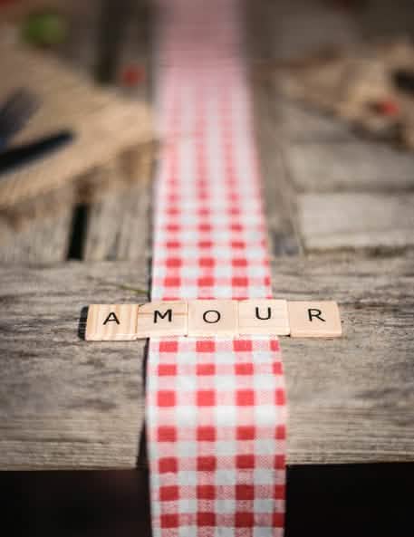 Beseda LJUBEZEN na karirastem namiznem tekaču iz 60 črk abecede v slogu scrabble za leseno dekoracijo mize