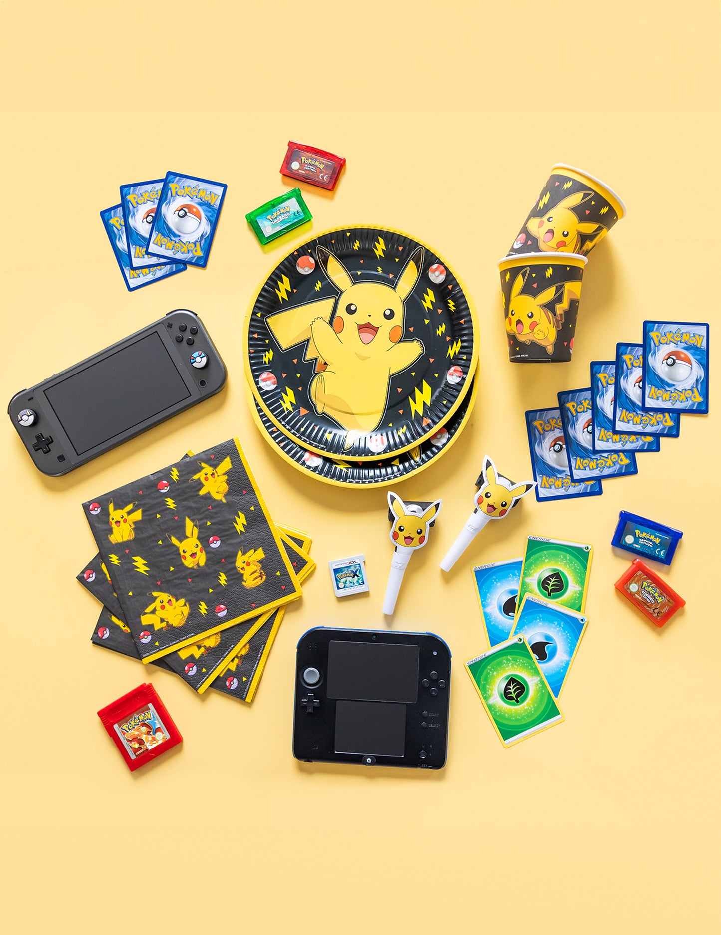 Mise en scène avec accessoires et consoles de jeux des assiettes en carton Pokémon Pikachu