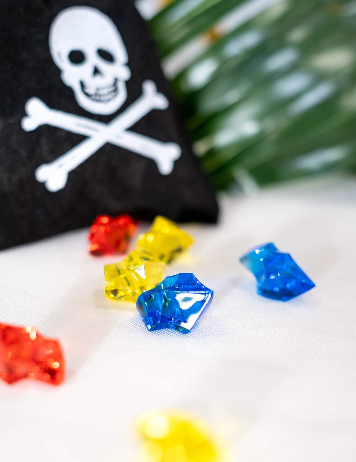 Bližnji posnetek večbarvnih dragih kamnov iz piratske torbice z lažnimi dragimi kamni