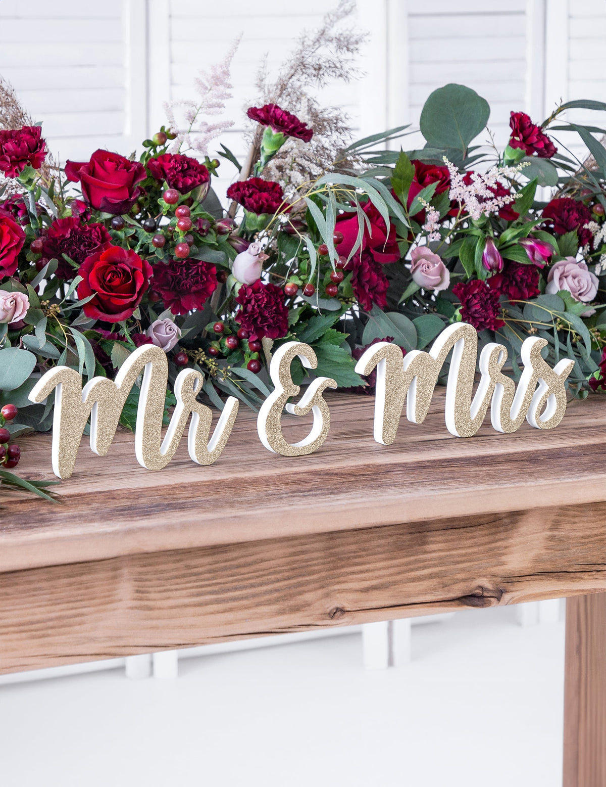 Mise en scène florale sur table de la décoration en bois Mr et Mrs pour mariage