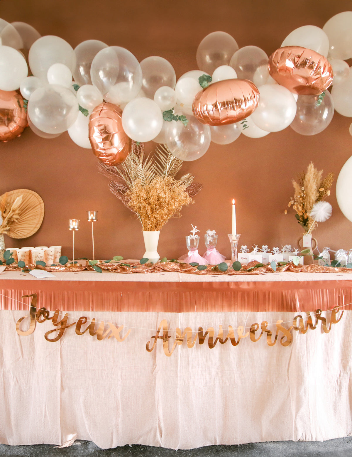 Mise en situation sur une table de fête de la guirlande Joyeux Anniversaire pour fête rose gold