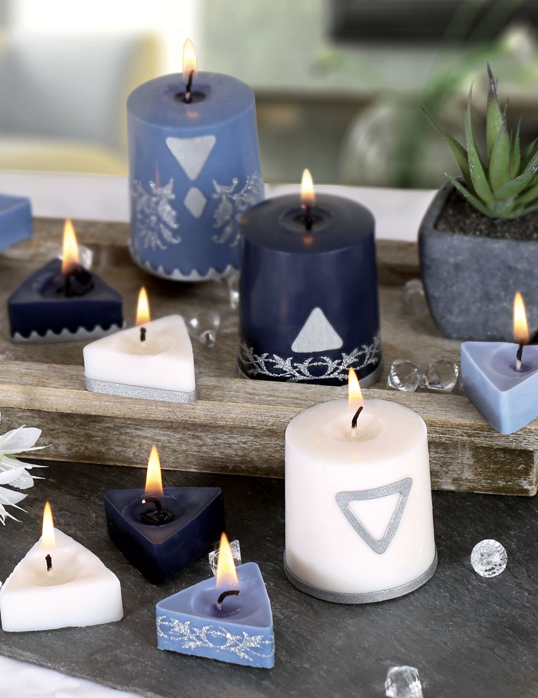 Mise en situation des bougies allumées du kit création de bougies géométriques blanches et bleues en cire végétale