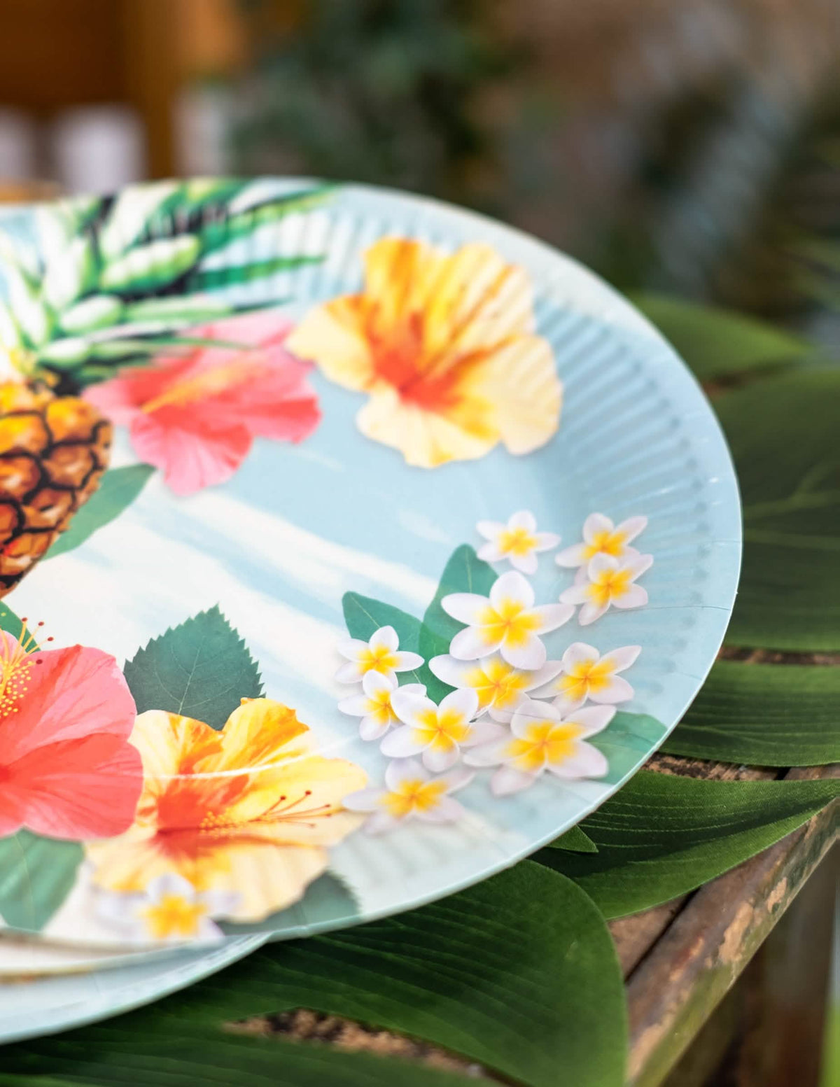 Bližnji posnetek cvetličnih vzorcev na papirnatih krožnikih Hawaii party
