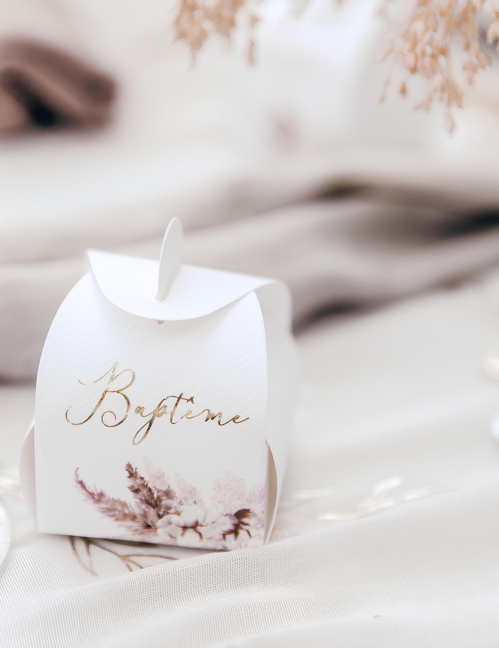 Gros plan sur l'inscription dorée du contenant baptême pampas et fleurs de coton