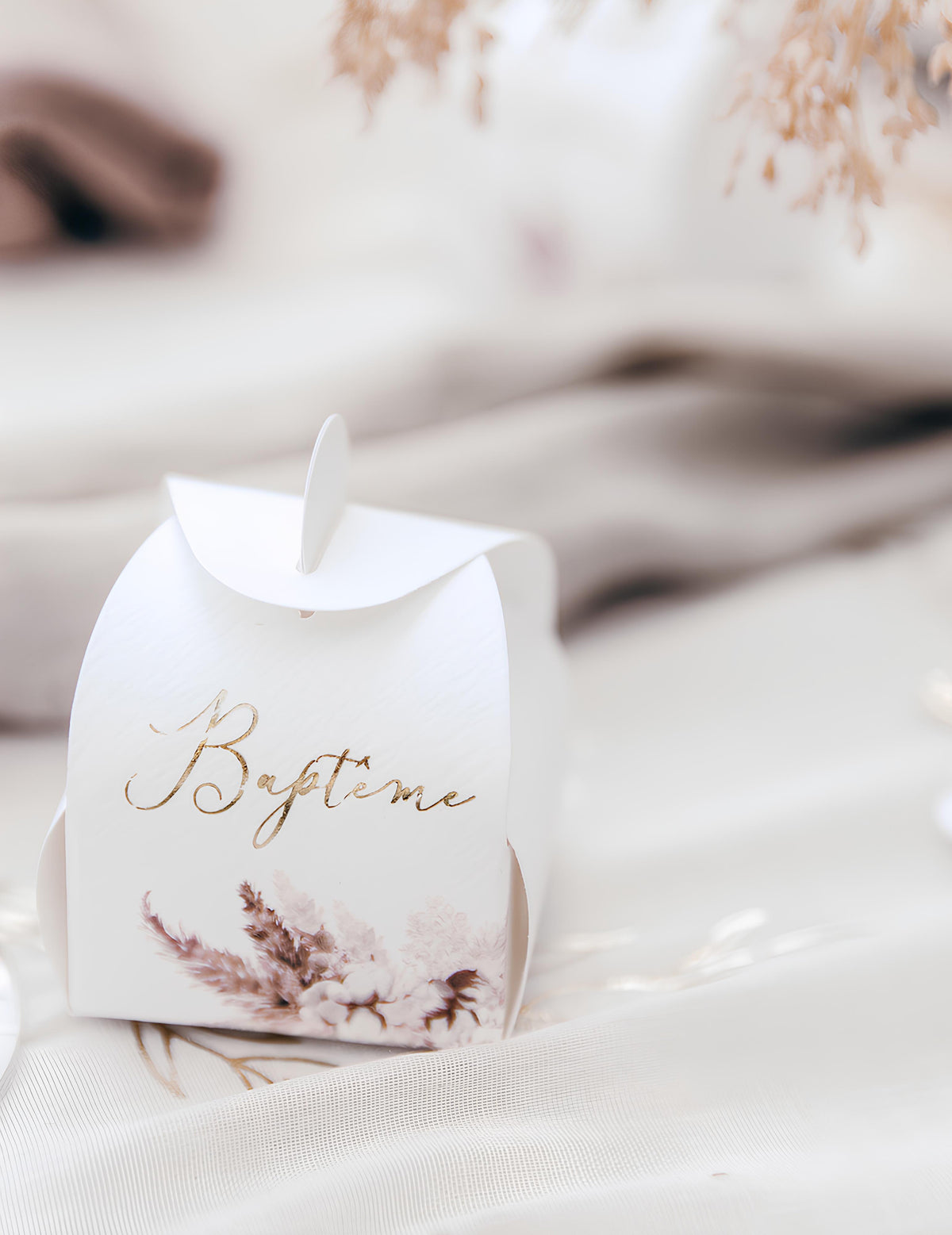 Gros plan sur l'inscription dorée du contenant baptême pampas et fleurs de coton
