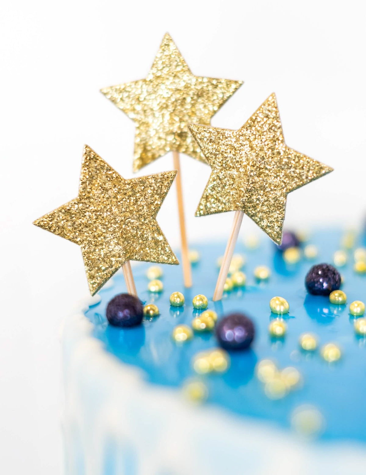 Velik plan na zlate bleščice cake topperja na palčki zvezdi za rojstni dan