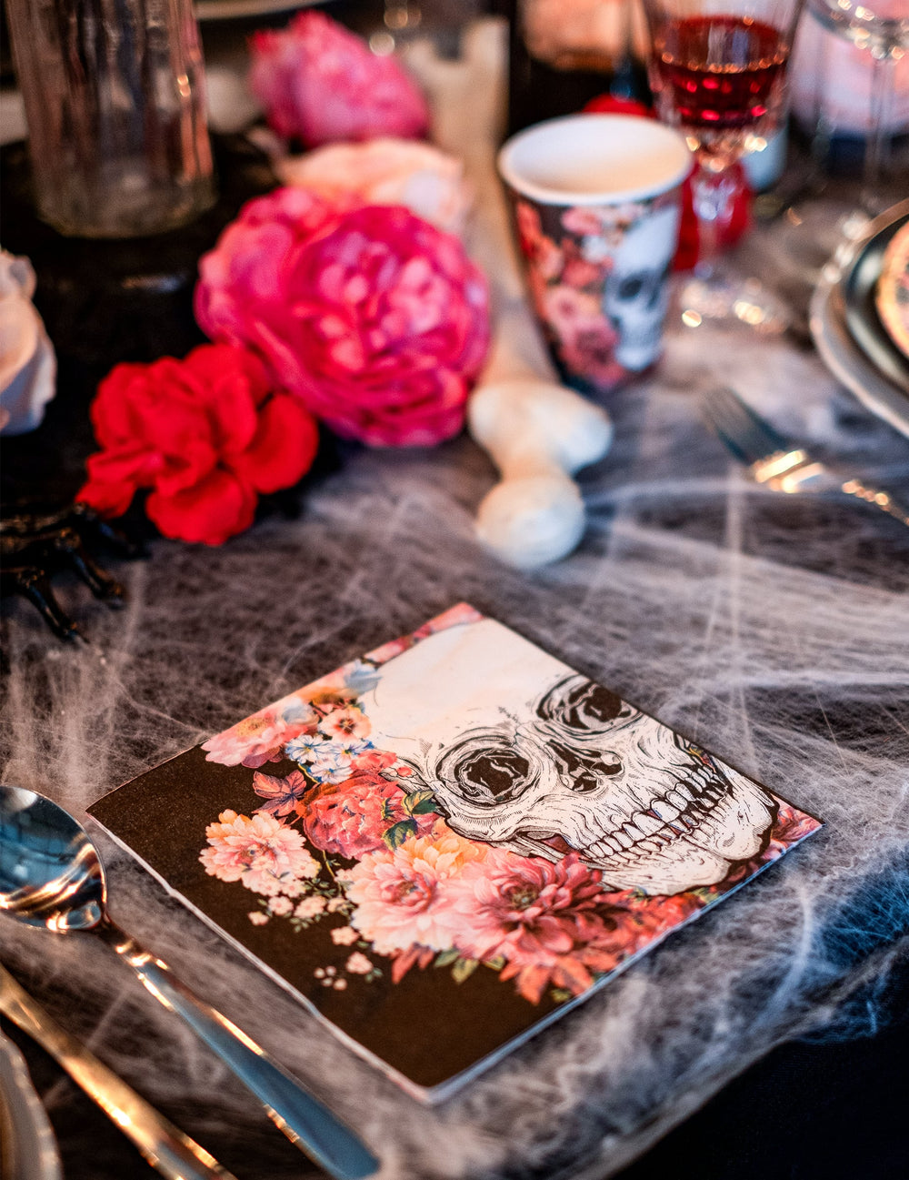 Zoom sur le motif crâne et fleurs roses des serviettes en papier squelette fleuri