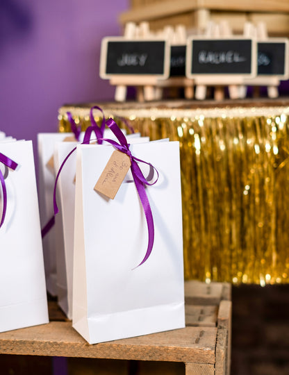 Mise en situation sur un sachet cadeau des étiquettes perforées de mariage pour fête
