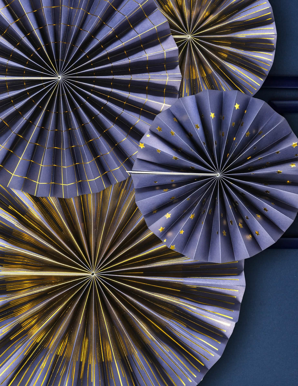 Bližnji posnetek zlatih vzorcev štirih okrasnih papirnatih rozet za zabavo