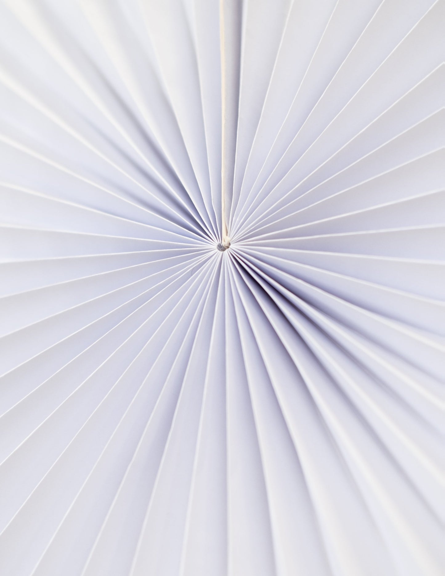 Détail du pliage central du lot de 5 rosaces en papier de décoration pour fête