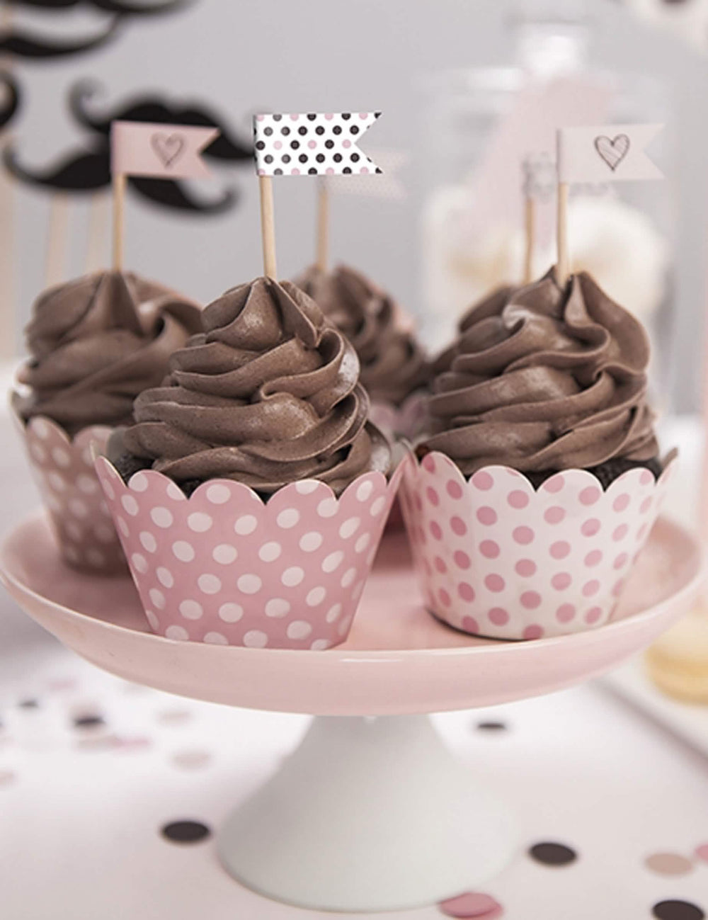 Postavitev ovojčkov za cupcake z roza pikami v pudrastem odtenku iz kartona