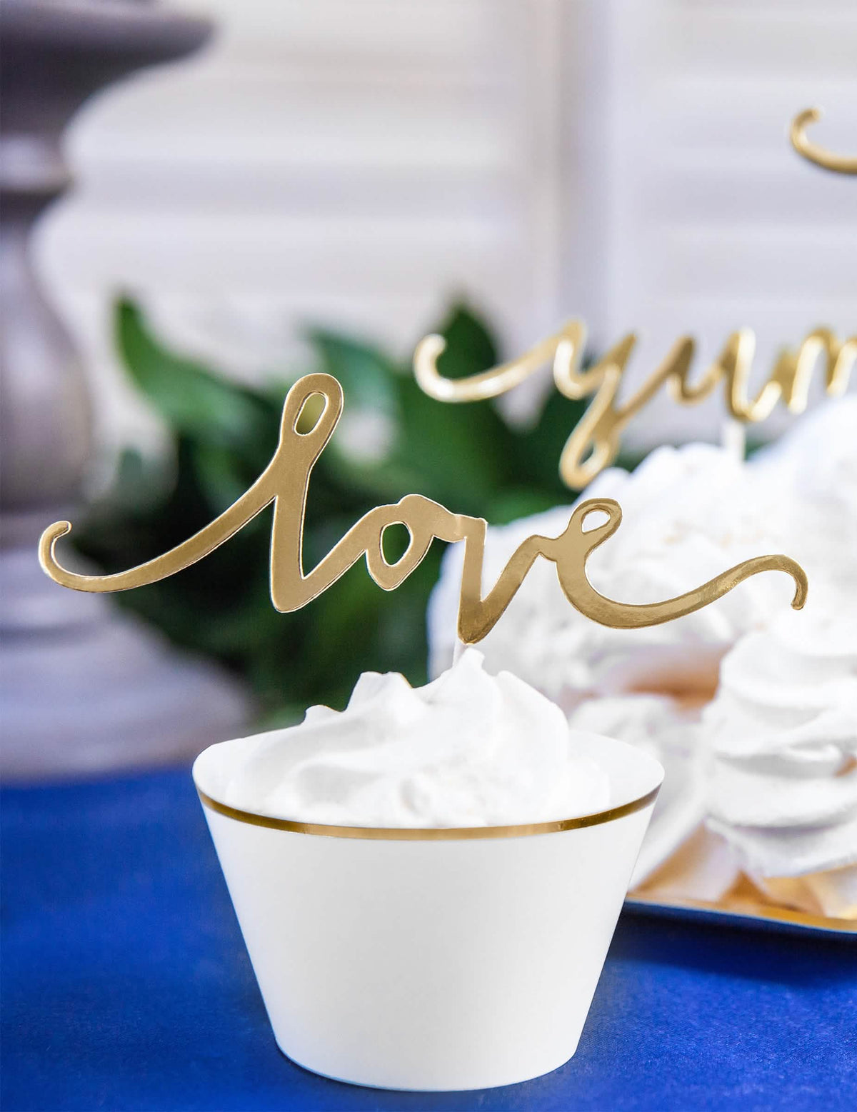Veliki plan na zlata cake topper love iz papirnatih ovojev za cupcake za poroko