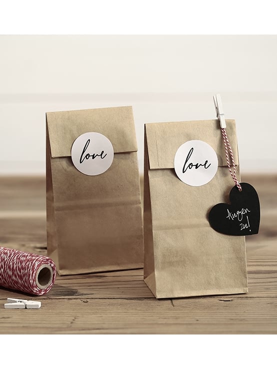 Mise en scène décorative des sachets kraft stickers love pour mariage