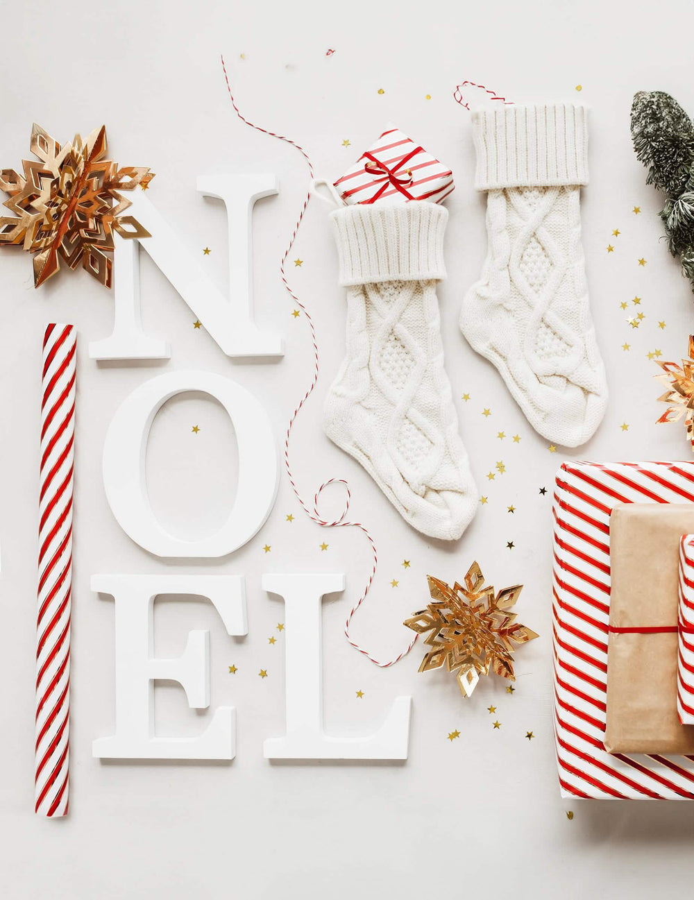 Scenografija s črkami NOEL iz visečega kartona in zlatimi snežinkami