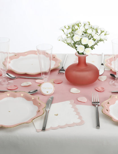 Mise en situation sur une table de fête des pétales en satin pour décoration ivoire rose et vieux rose