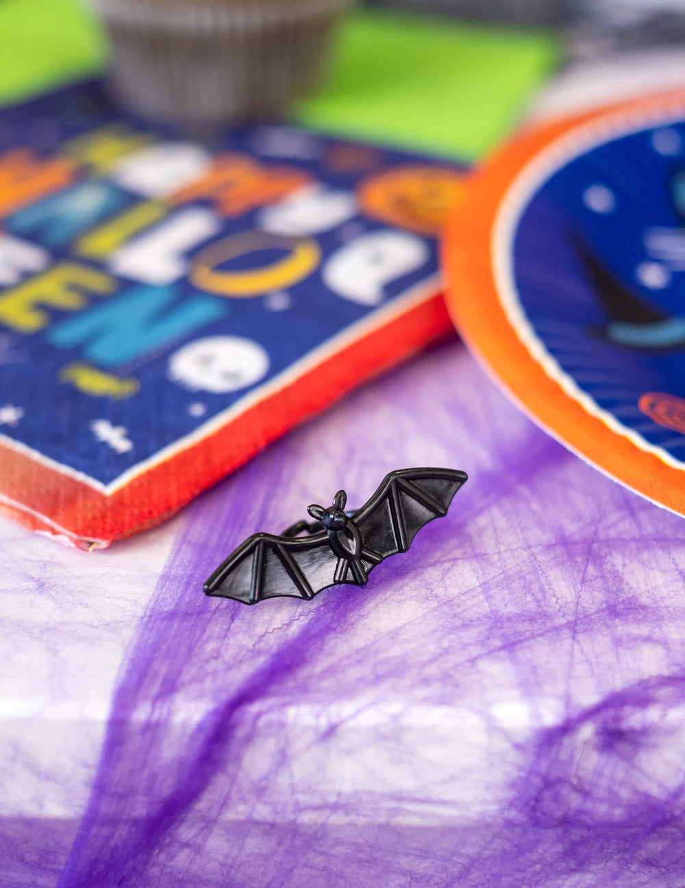 Bližnji posnetek črnega netopirjevega prstana iz plastičnih prstanov z netopirji in pajki za halloween