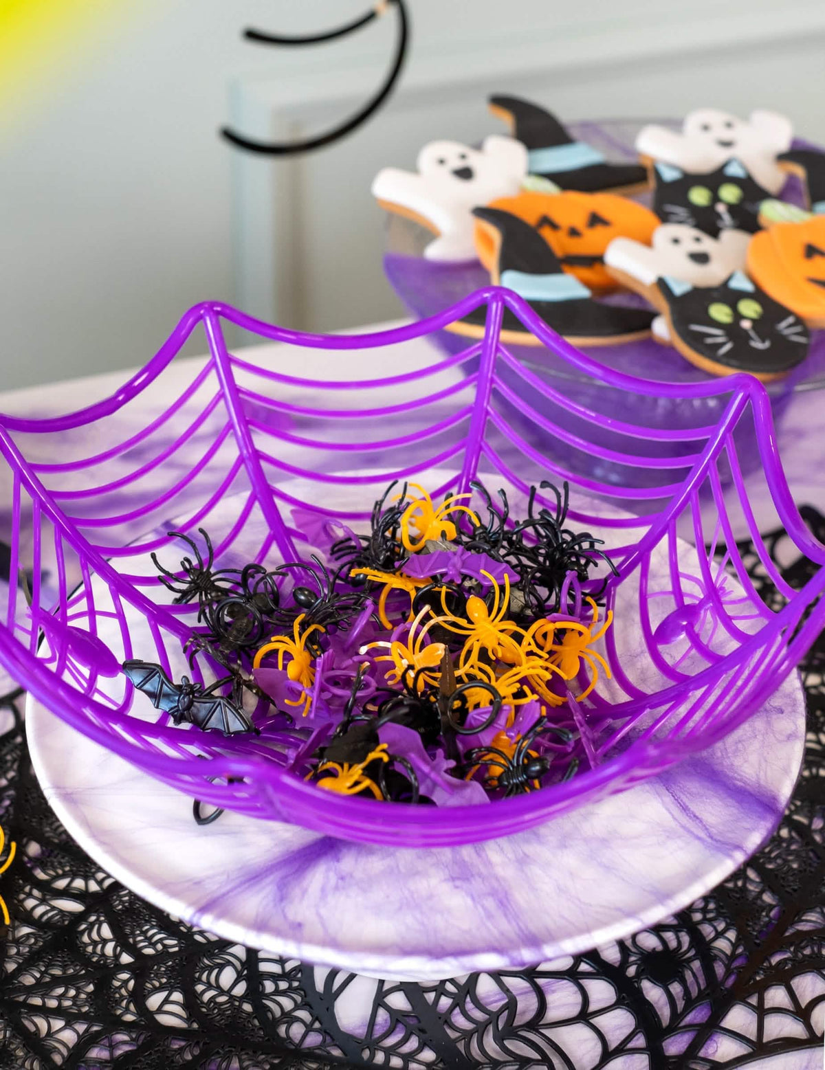 Košara iz pajčevine, napolnjena z plastičnimi prstani v obliki netopirja in pajki za halloween