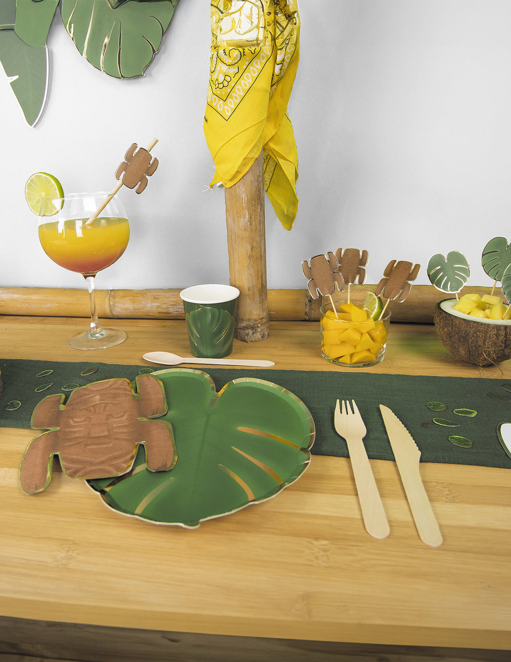 Mise en scène de table des assiettes en carton feuilles tropicales