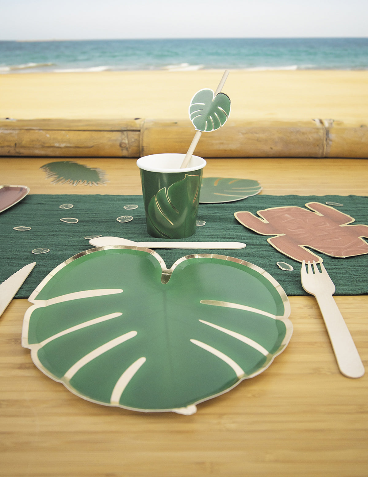 Détail de la décoration de table des assiettes en carton feuilles tropicales