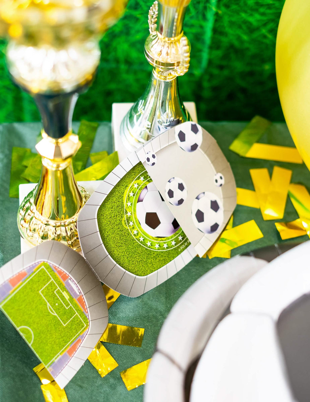 Pogled z zlatimi trofejami na vabila s kuvertami za nogometni stadion za otrok