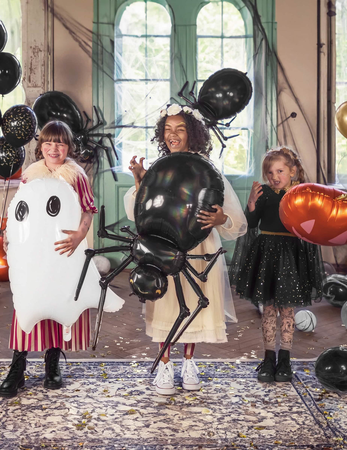 Postavitev za halloween z otroki in aluminijastim balonom pajkom