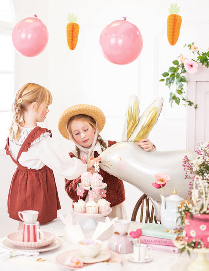 Mise en scène de deux enfants à table du ballon aluminium lapin pour Pâques
