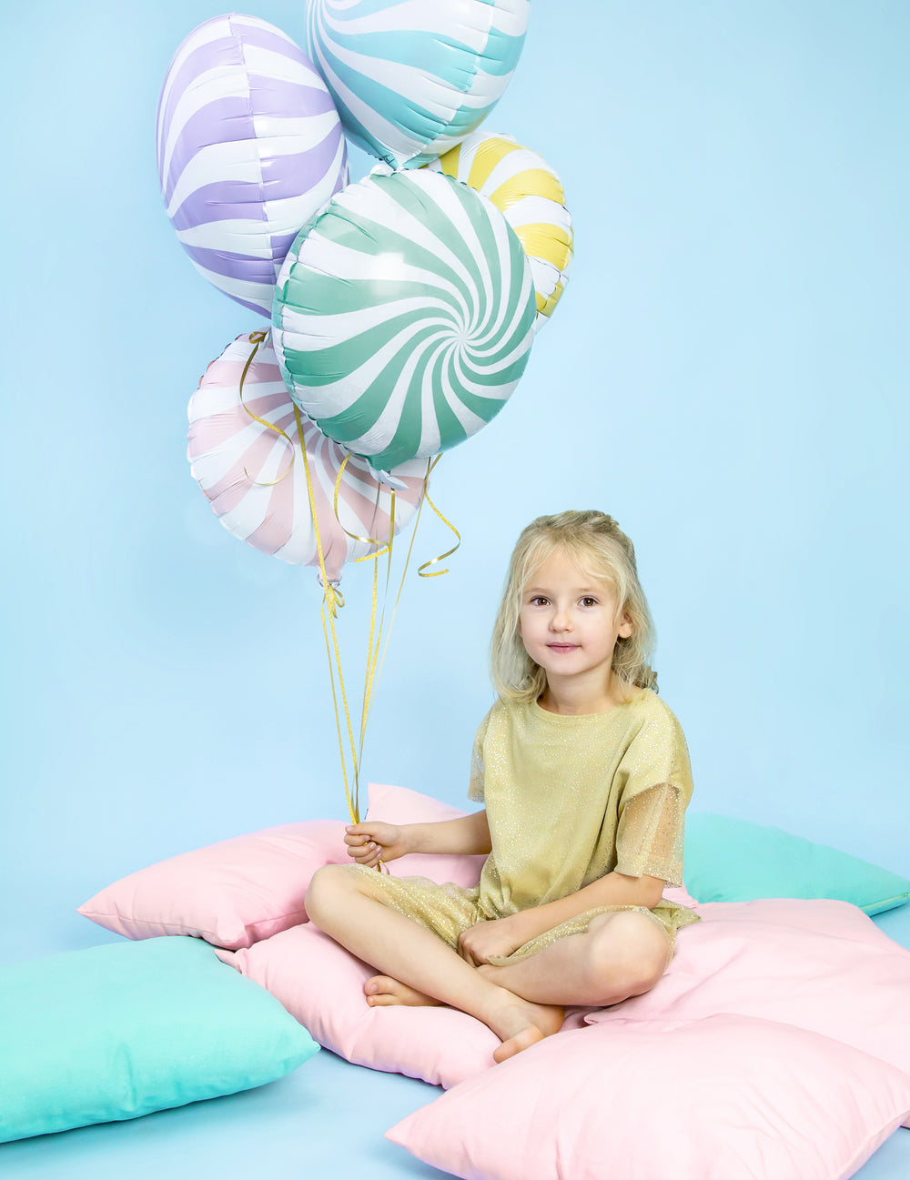 Mise en situation du ballon aluminium sucette pour fête menthe et blanc à spirales tenu par une enfant
