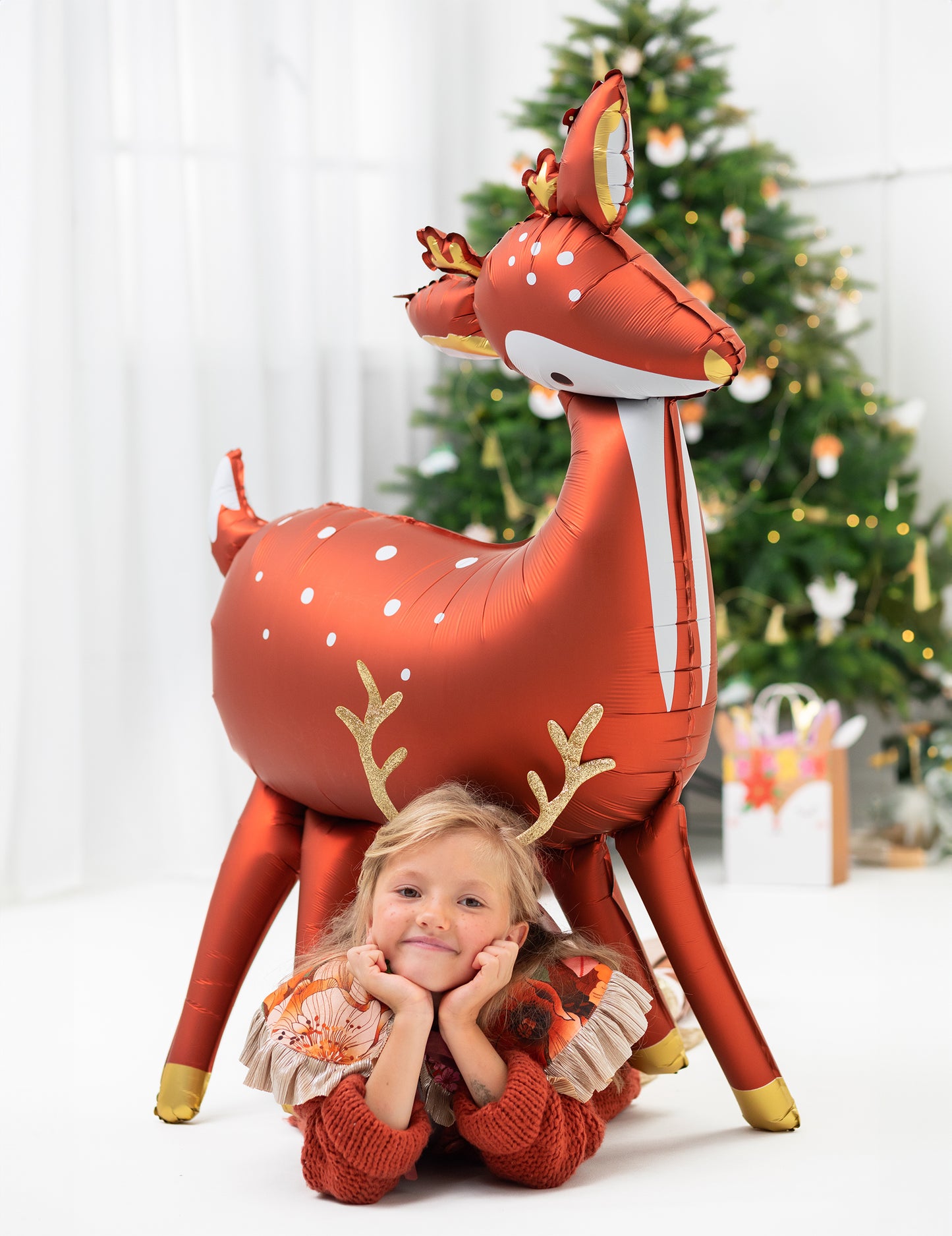 Enfant allongé devant le ballon géant en aluminium biche