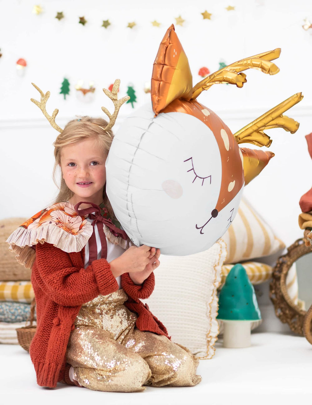 otrok, ki drži velikanski aluminijasti balon v obliki jelenje glave