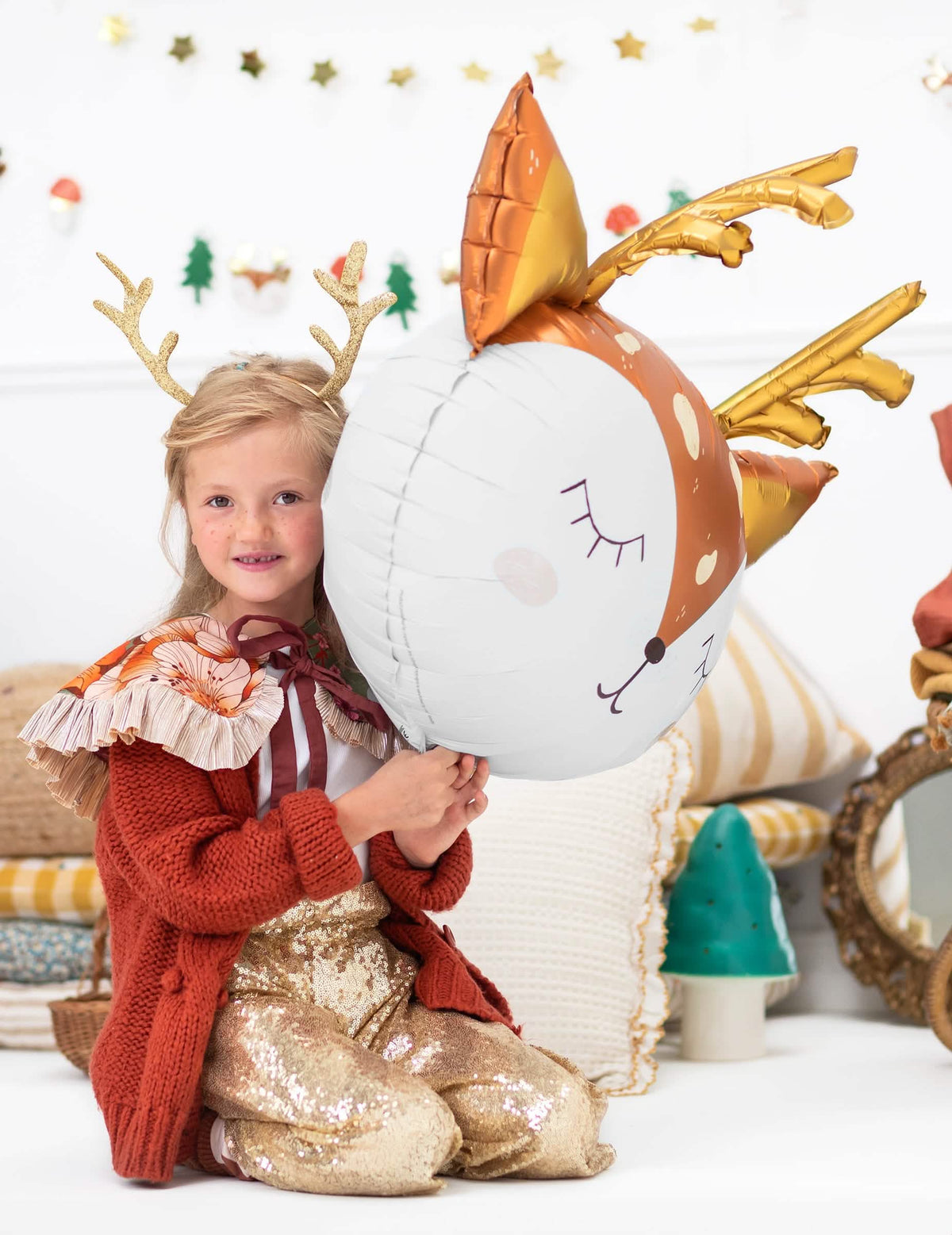 otrok, ki drži velikanski aluminijasti balon v obliki jelenje glave