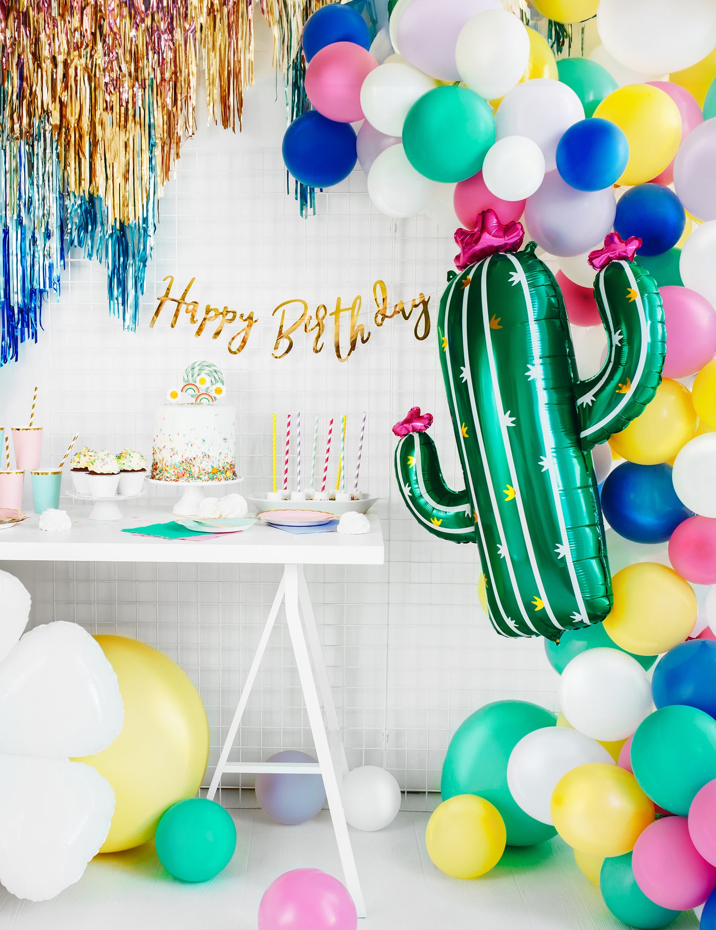 Mise en scène de fête d'anniversaire avec buffet et arche de ballons du ballon cactus en fleurs