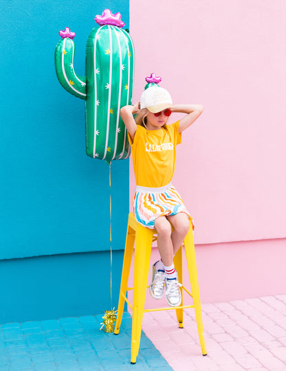 Mise en scène avec enfant sur un tabouret du ballon cactus en fleurs