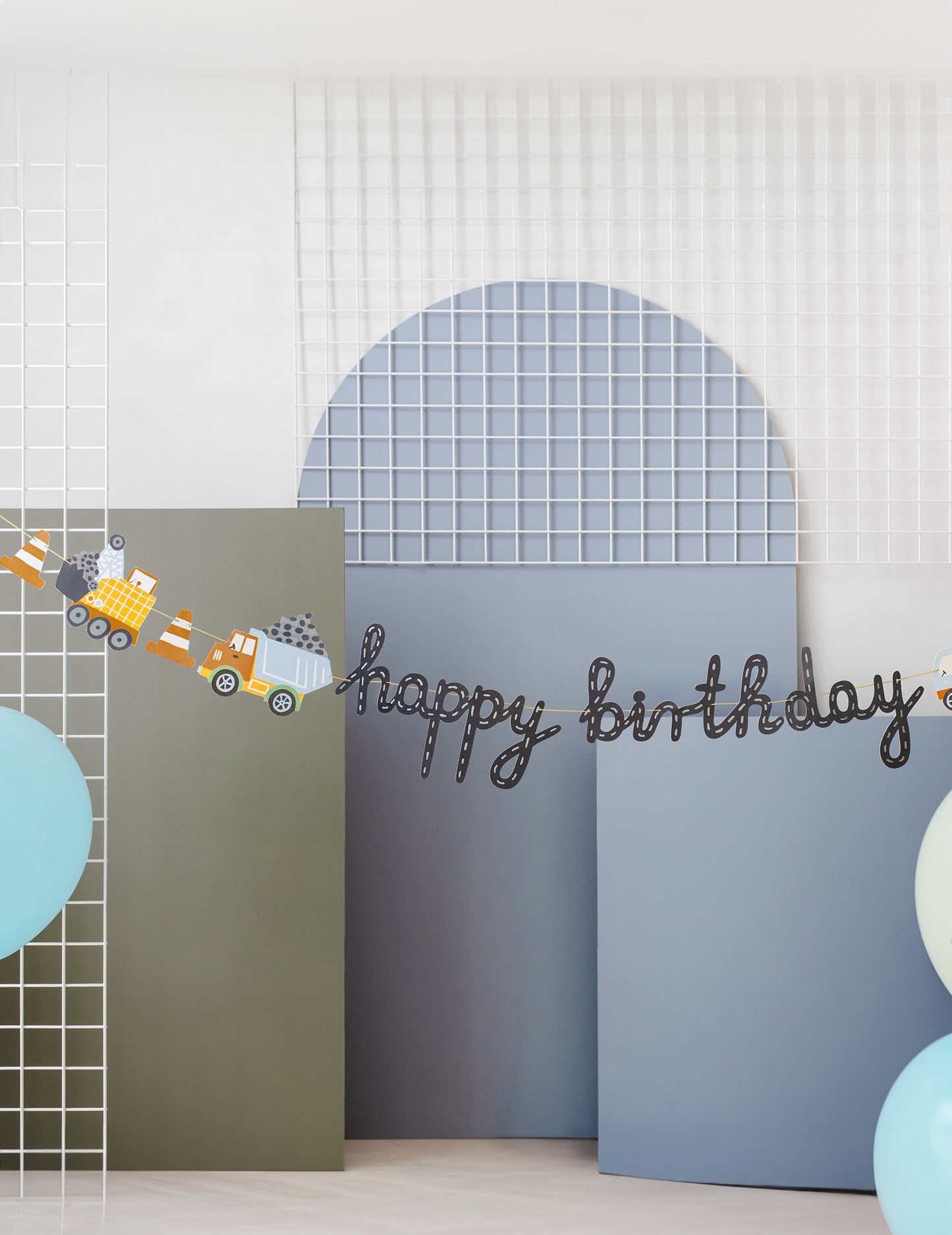 Gros plan sur l'inscription et les engins de la bannière Happy Birthday camions de chantier