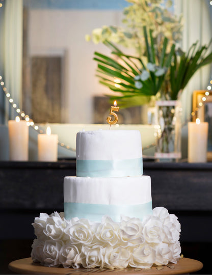 Mise en situation sur un gâteau de la bougie d'anniversaire chiffre 5 doré métallisé sur pique