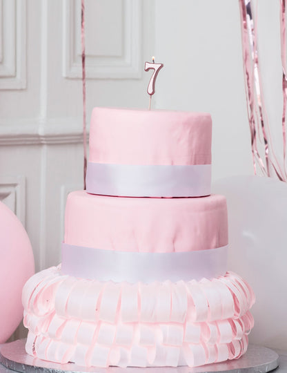 Mise en situation sur un gâteau de la bougie d'anniversaire chiffre 7 rose gold métallisée