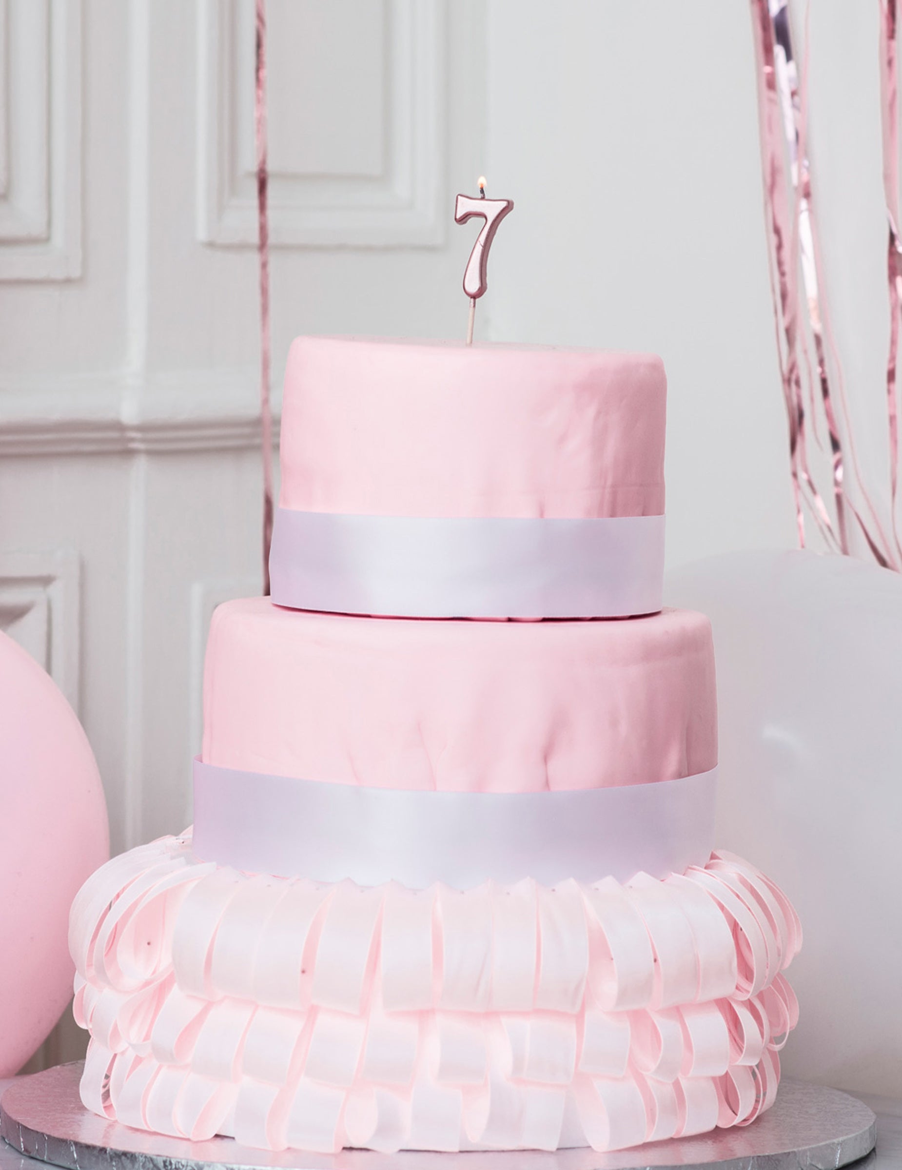 Mise en situation sur un gâteau de la bougie d'anniversaire chiffre 7 rose gold métallisée