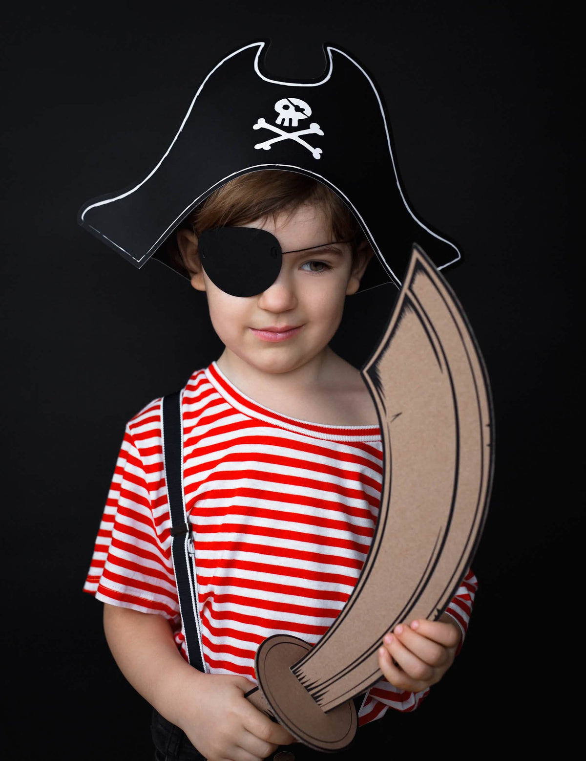 Prikaz situacije z kartonskim mečem piratskega klobuka in otroškim prevezo za oči