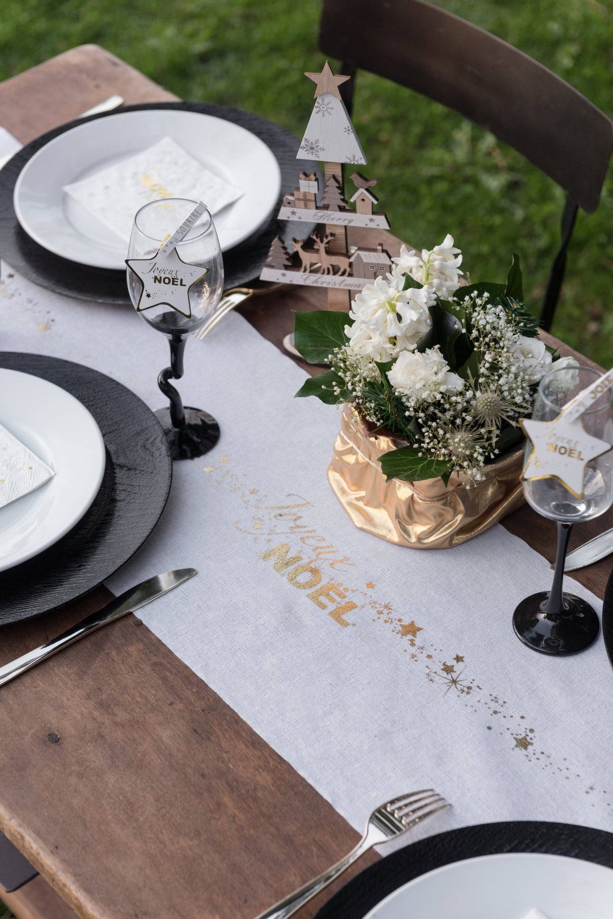 Mise en situation sur une table de fête du chemin de table en coton Joyeux Noël