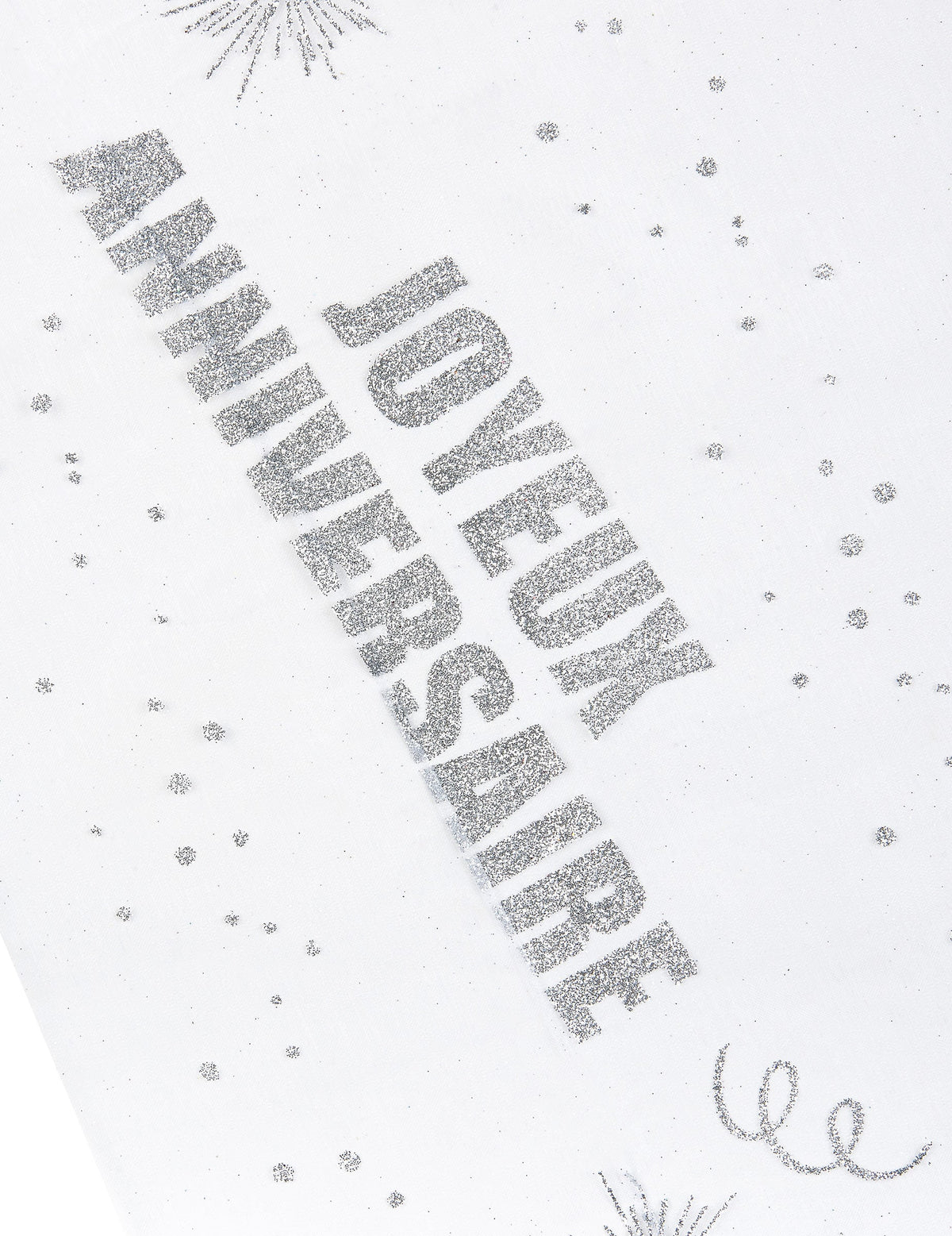 Gros plan sur l'inscription du chemin de table organza Joyeux anniversaire argent pailleté