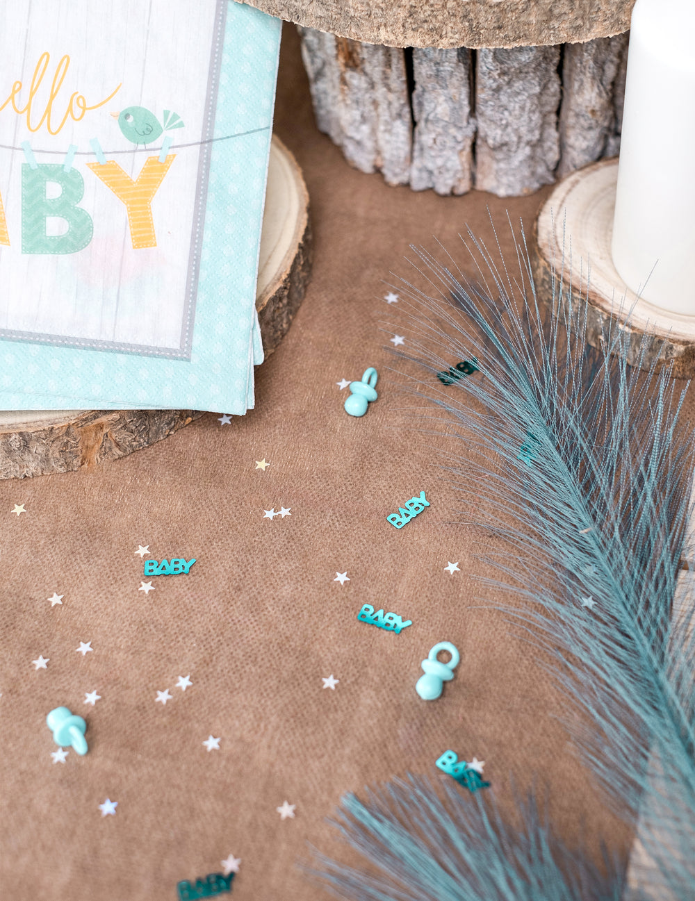 Mise en situation sur une table des confettis tétine baby pour baby shower bleu