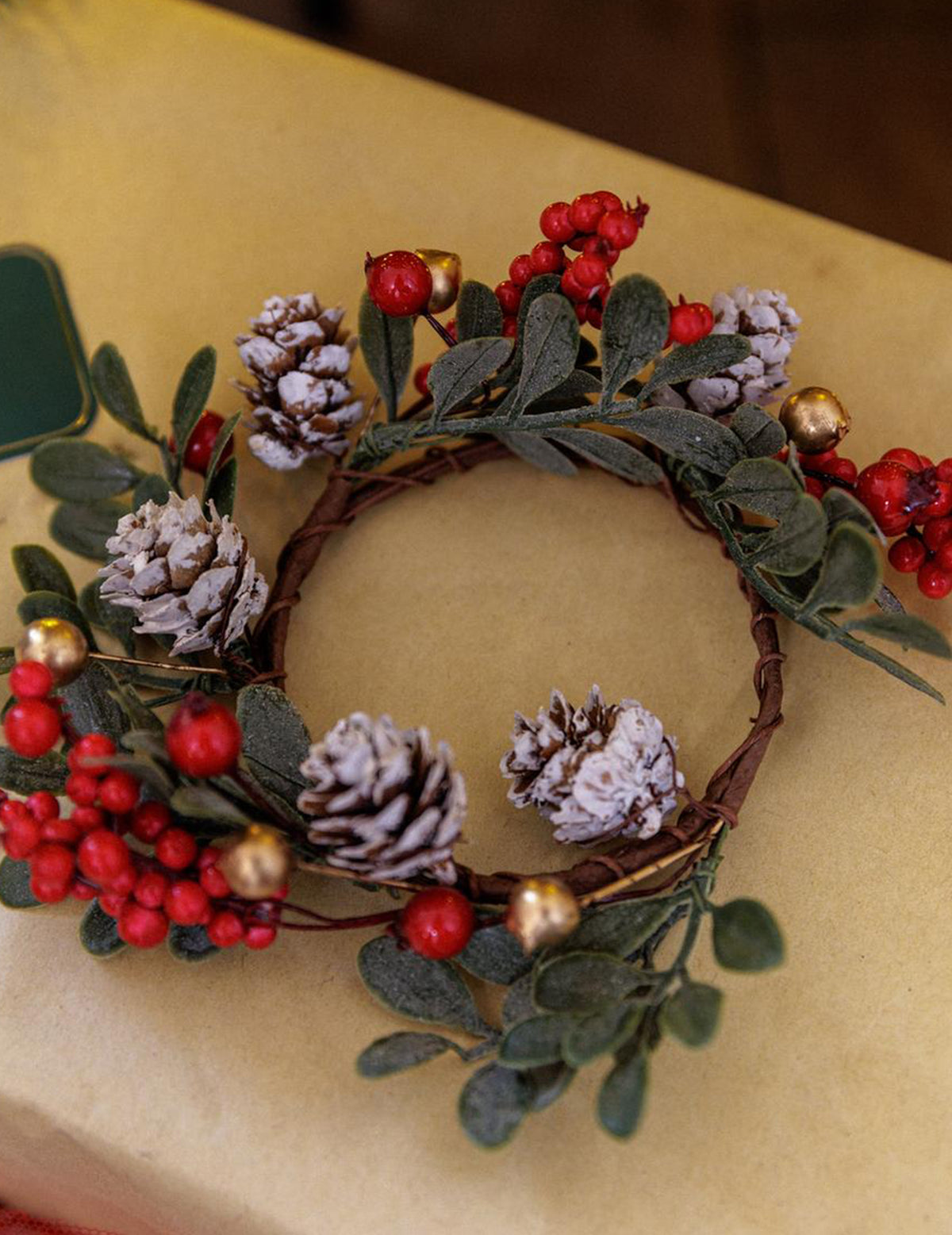 Venec iz listja jagodičja in storžev zelena rdeča in zlata 15 cm