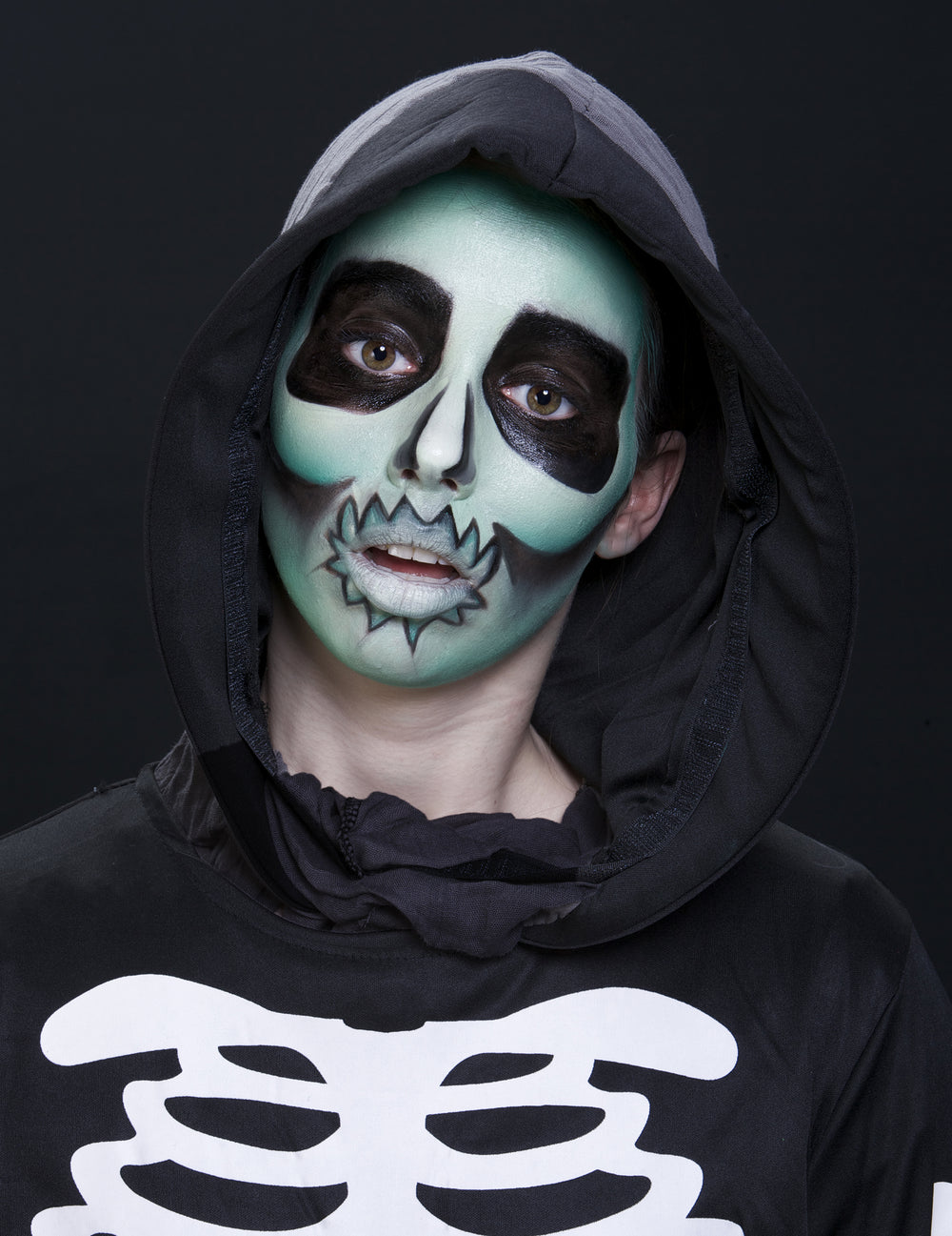 Gros plan sur le maquillage de squelette vert réalisé avec la crème phosphorescente maquillage fluo