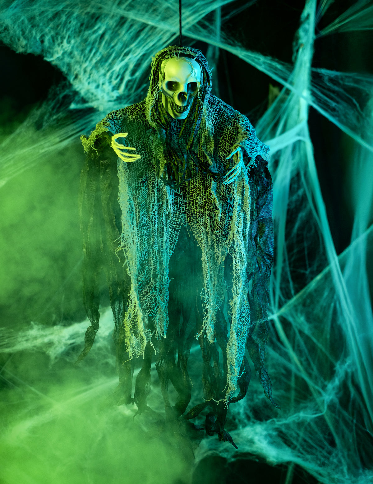 Mise en situation dans un décor terrifiant de la décoration à suspendre faucheuse Halloween