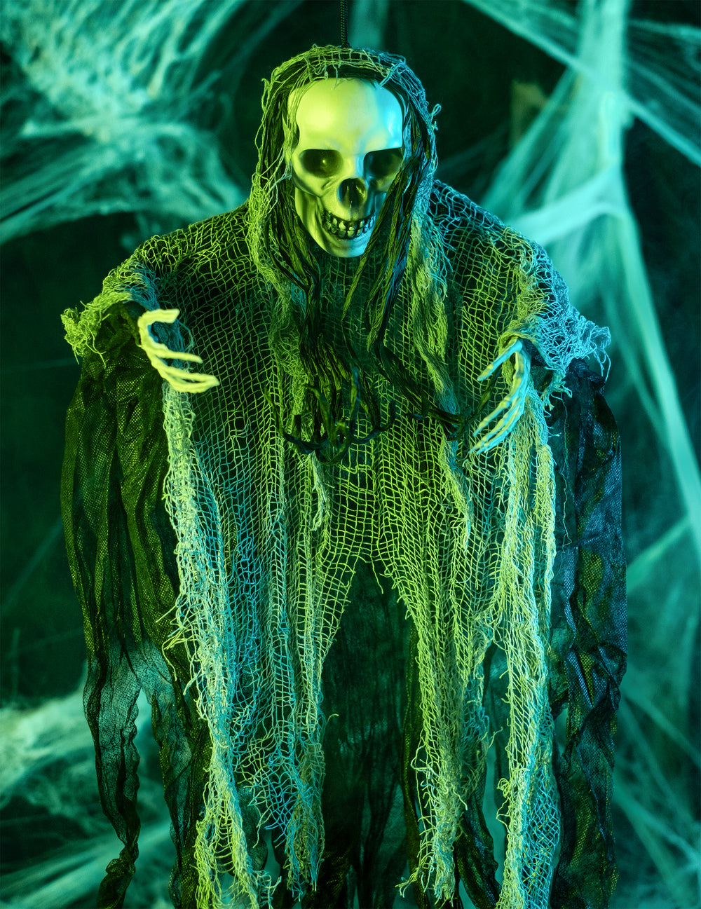 Mise en scène sous éclairage vert de la décoration à suspendre faucheuse Halloween