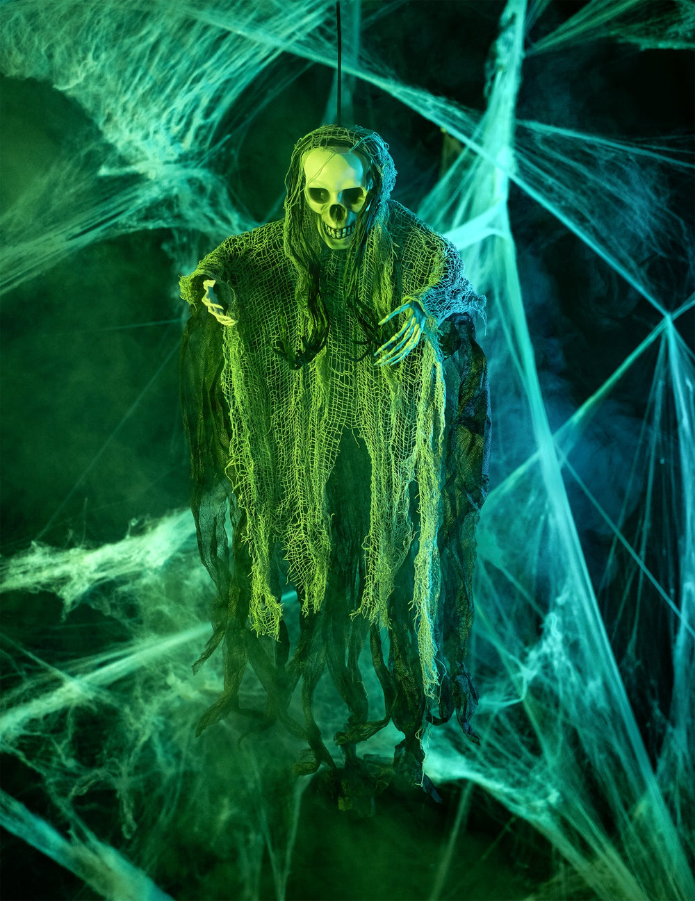 Mise en scène sous éclairage vert de la décoration à suspendre faucheuse Halloween